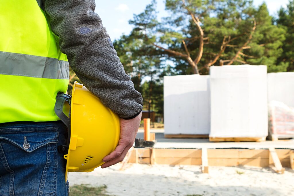 A construction worker holding a hardhat at a job site on VCE's website.