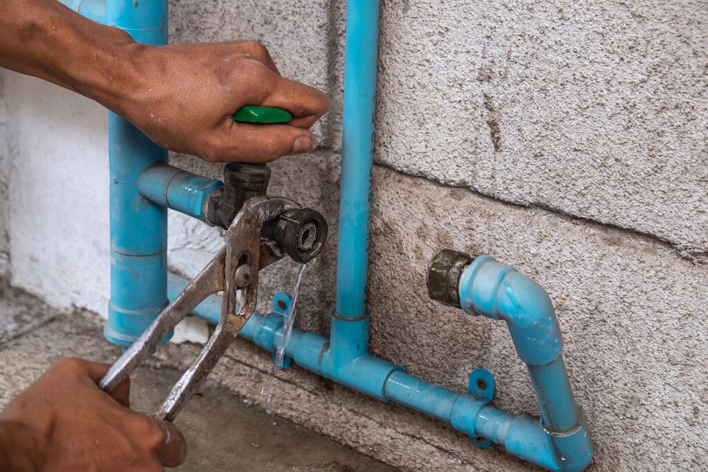 Image of a water leak repair technician repairing a leak near a water meter on VCE's website
